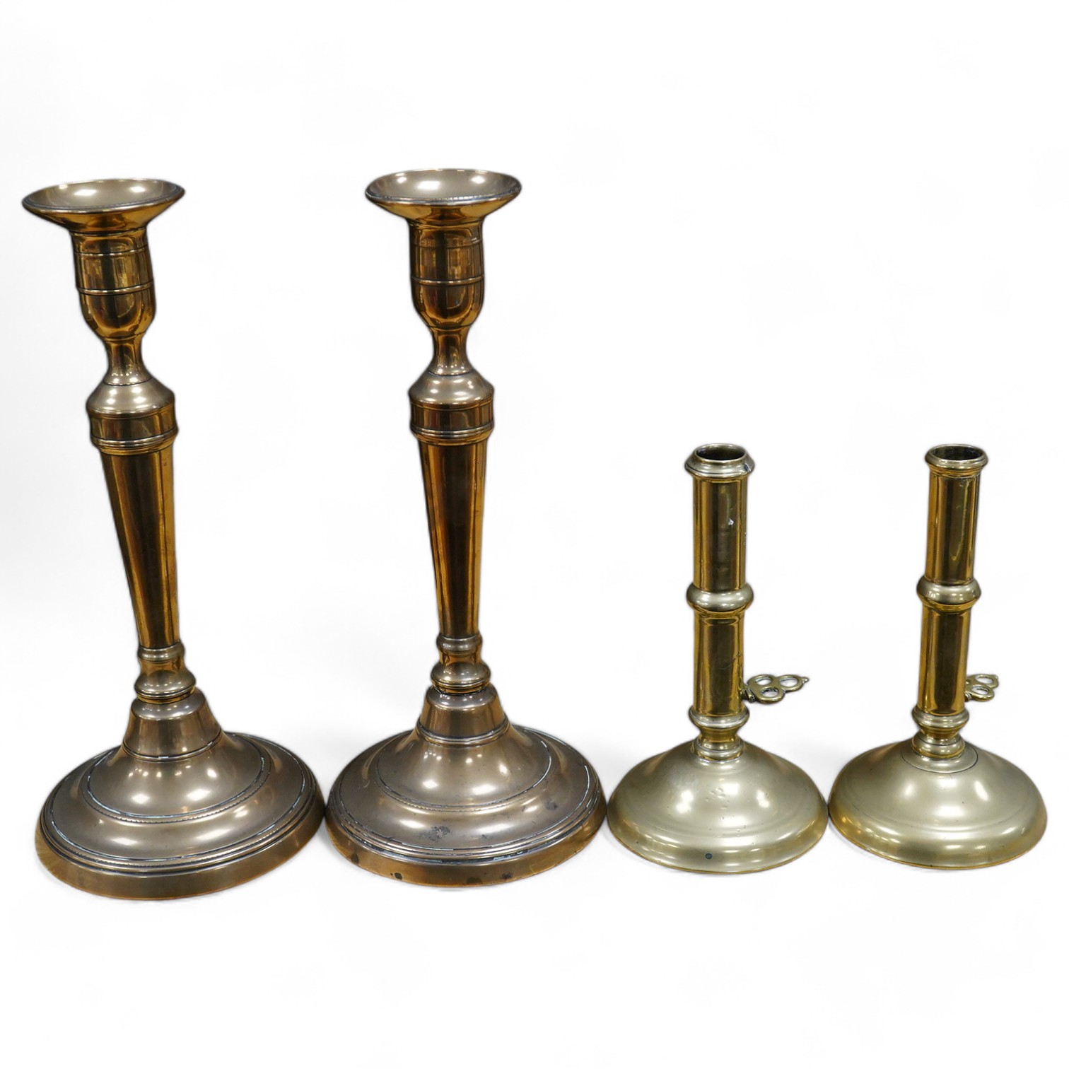 Two pairs of candlesticks to include 18th century brass ejector examples, 37cm wide. Condition - good